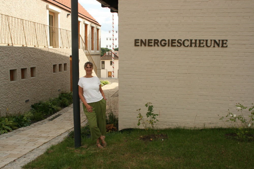 Kathrin Tröster lehnt sich an eine Laterne direkt neben der neuen Niederwerrner Energiescheune.